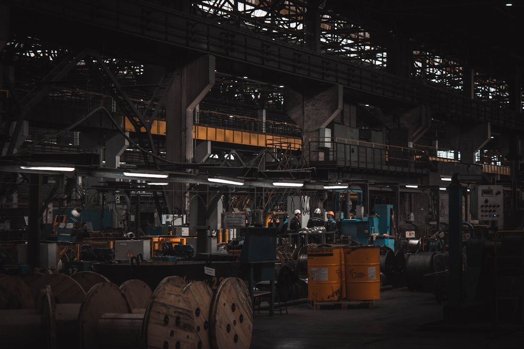 Blick in eine industrielle Produktionshalle mit Autoteilen und Versandmaterialien.
